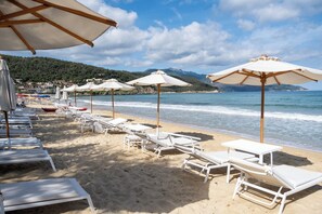 Sulla spiaggia, sabbia bianca, lettini da mare, ombrelloni
