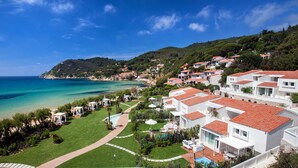 A coastal resort with white buildings, red-tiled roofs, and a clear view of the sea. - Baia Bianca Suites (Portoferraio)