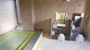 Une salle de bain avec une grande baignoire, une douche et un lavabo avec un miroir.