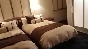 Une chambre d’hôtel avec deux lits, une table de chevet et une armoire.