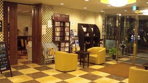 A checkered floor, a comic library, and seating areas in a lobby. - Kuretake Inn Fujisan (Fuji)