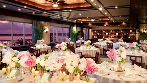 A restaurant with round tables set for dining, featuring floral centerpieces and candles. - Hamanako Resort & Spa The Ocean (Hamamatsu)