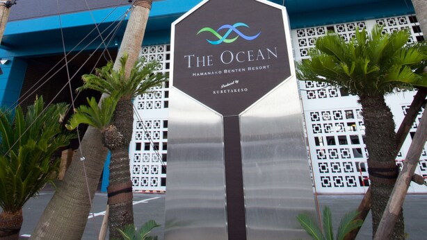 A hotel entrance with palm trees and a sign that reads "The Ocean". - Hamanako Resort & Spa The Ocean (Hamamatsu)