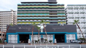 A multi-story hotel with balconies, a sign reading "The Ocean," and a parking area in front. - Hamanako Resort & Spa The Ocean (Hamamatsu)