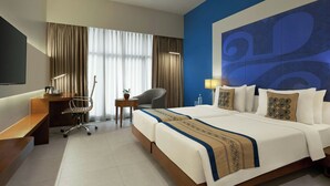 A hotel room with a bed, desk, chair, and a large wall decoration. - The Fern Residency Mumbai, The Acres Chembur, Series by Marriott (Mumbai)