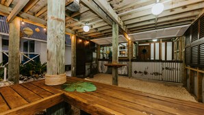 A rustic wooden interior with exposed beams, a wooden bench, and a rustic dining table. - The Passage Villas (Rarotonga)