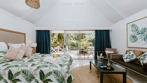 A bedroom with a bed, a sofa, a table, and a view of the outdoors. - The Passage Villas (Rarotonga)