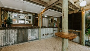 A rustic interior with a wooden ceiling, a wooden table with a rope handle, and a corrugated metal wall. - The Passage Villas (Rarotonga)