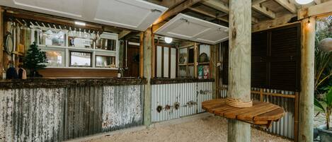 A rustic interior with a wooden ceiling, a wooden table with a rope handle, and a corrugated metal wall.
