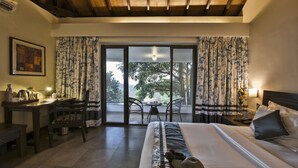 A hotel room with a bed, a desk, a chair, a table, and a view of the outdoors. - The Fern Samali Resort Dapoli, Series by Marriott (Dapoli)