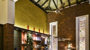 A bar area with a brick wall, a wooden ceiling, and a bar counter with stools. - The Fern Samali Resort Dapoli, Series by Marriott (Dapoli)
