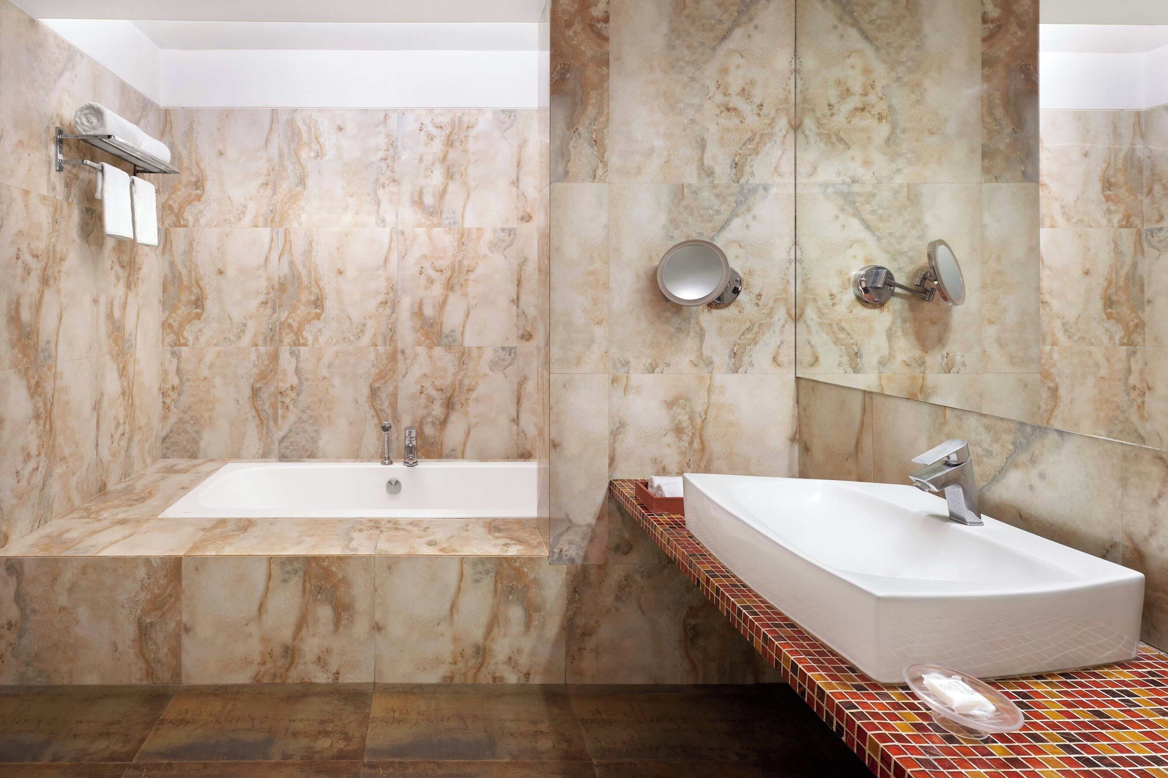 Un baño moderno con bañera, lavamanos y ducha.