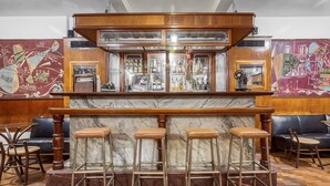 A bar area with a marble countertop, stools, and a mural on the wall. - Amazonas Palace Hotel Belo Horizonte - Avenida Amazonas (Belo Horizonte)