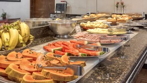 A buffet with various fruits and meats. - Amazonas Palace Hotel Belo Horizonte - Avenida Amazonas (Belo Horizonte)