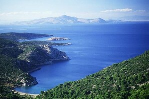Un paisaje costero con vistas claras al mar y montañas distantes.