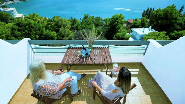 Una terrazza con vista su un lago, immersa nel verde.