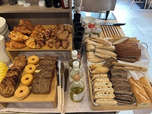 A variety of baked goods including croissants, bread, and pastries on display. - Hotel Llafranch (Palafrugell)