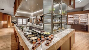 Un espace buffet proposant divers plats et une vitrine réfrigérée.