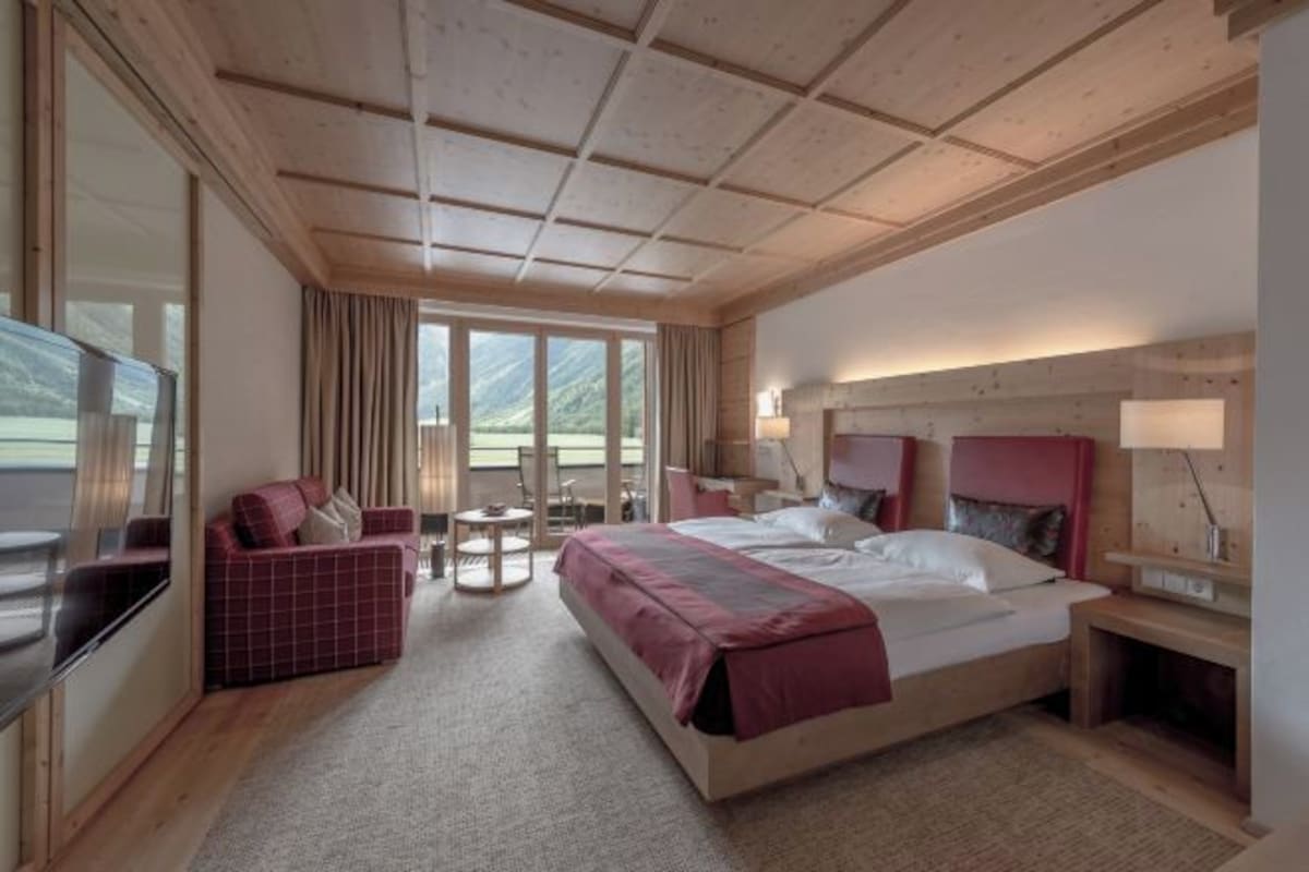 Una habitación de hotel con una cama grande, un sofá, un escritorio y un televisor.