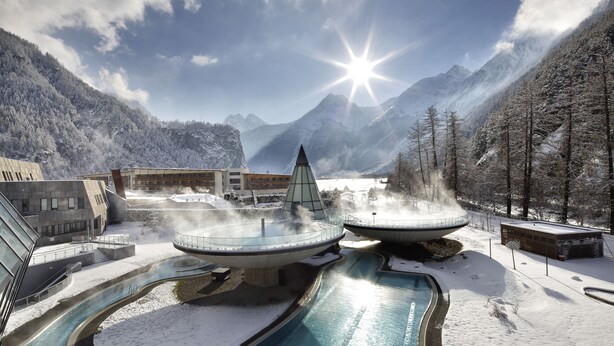 Un spa moderne doté d’un jacuzzi, d’une piscine et offrant une vue sur les montagnes.