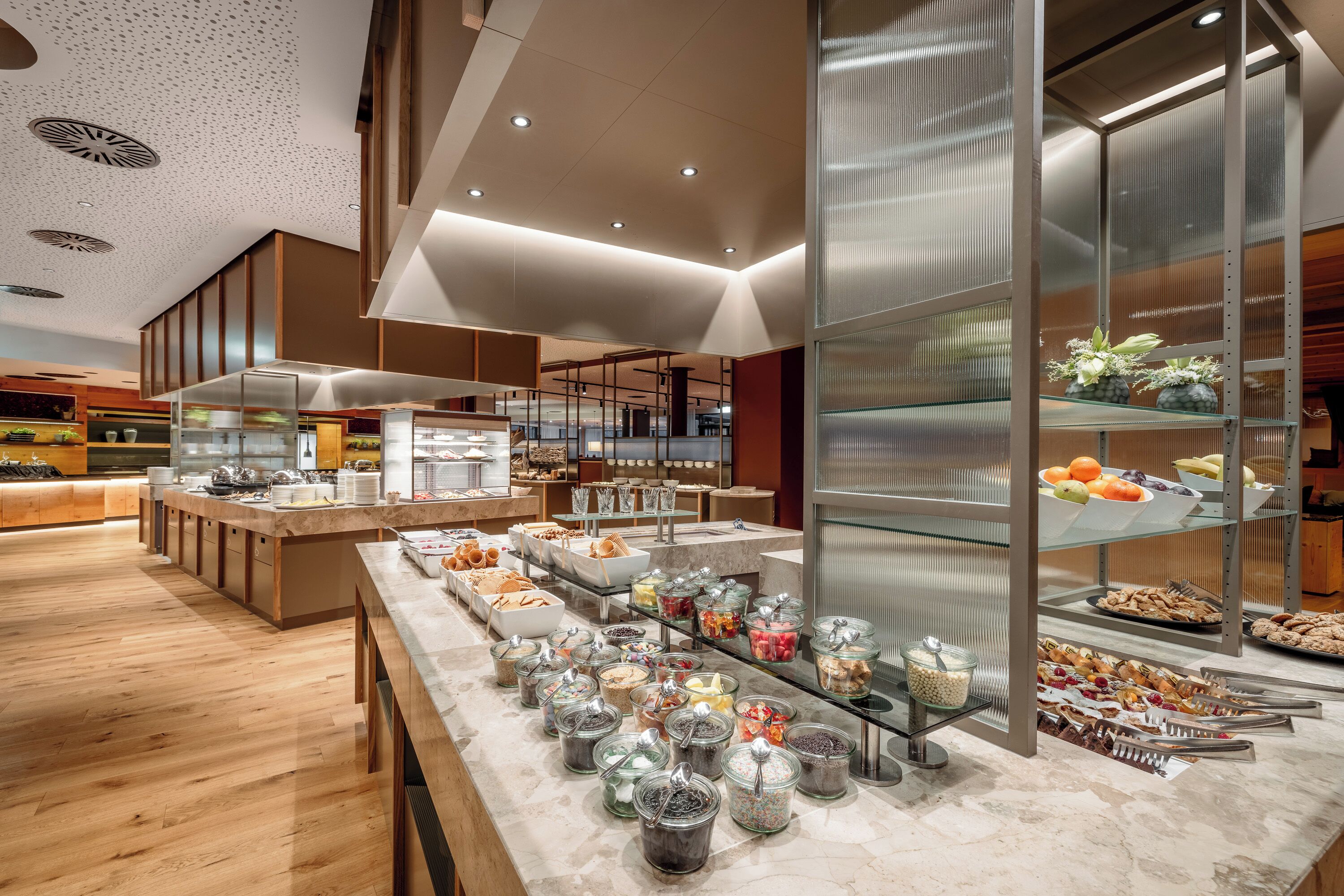 A modern buffet setup with various food items and a clean, contemporary interior design.