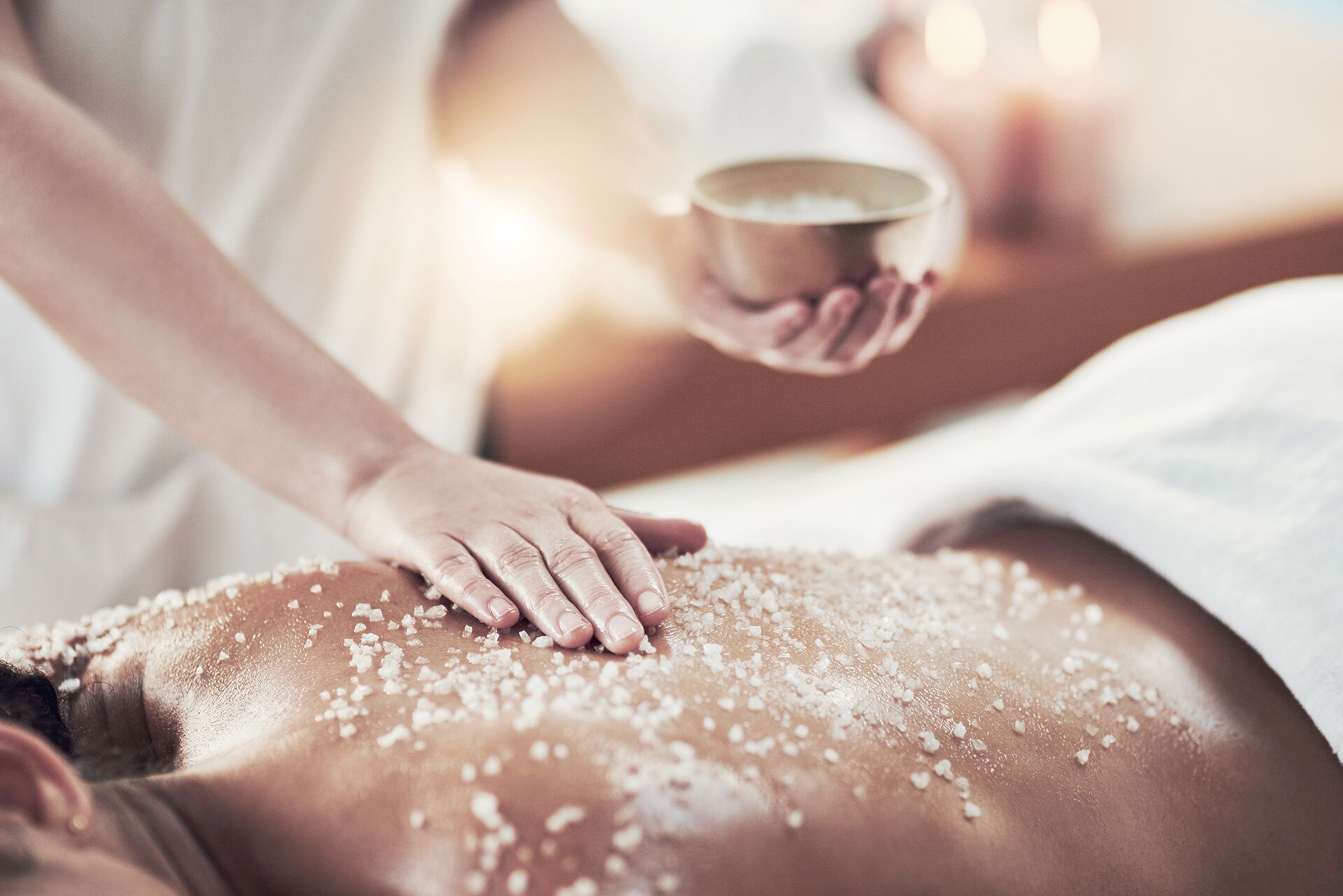 Una persona recibiendo un tratamiento de exfoliación con sal.