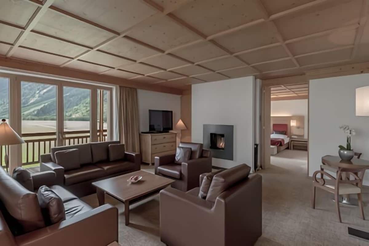 A spacious living area with a fireplace, comfortable seating, and a television.