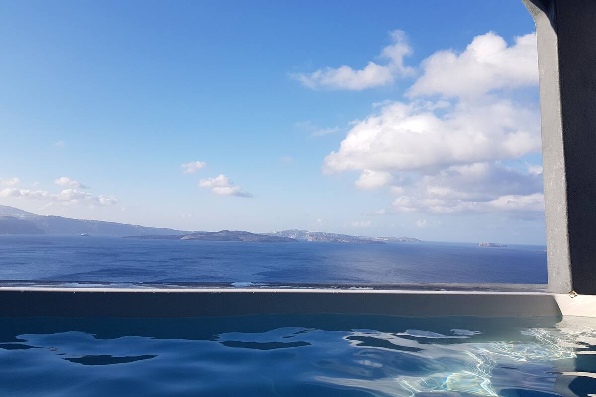 Vistes des d'un balcó amb una piscina, sobre un cos d'aigua i paisatges llunyans.