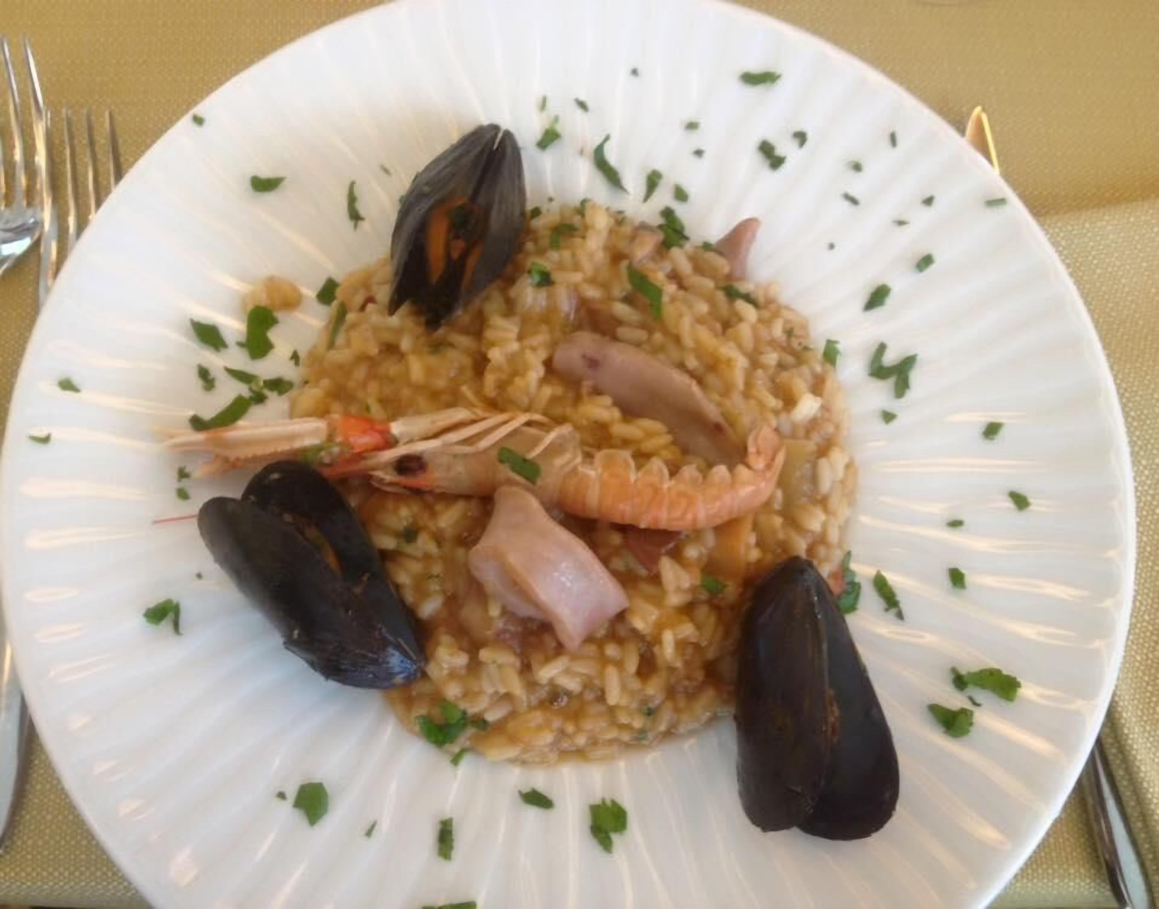 Un plato de risotto de mariscos con mejillones, camarones y almejas.