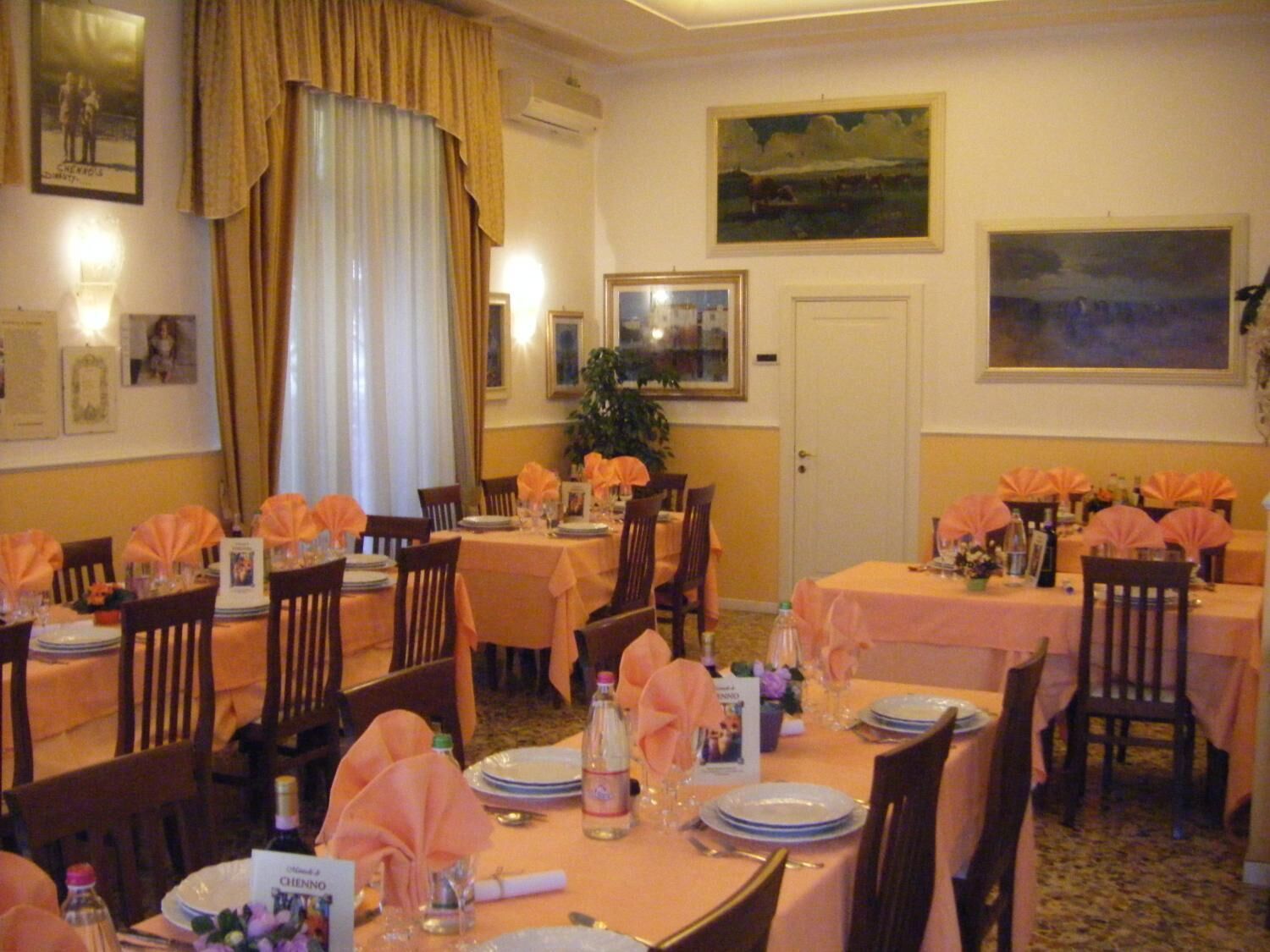 A dining area with tables set for a meal, featuring a consistent color scheme and formal table settings.
