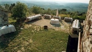 Un espacio de comedor al aire libre con paredes de piedra y mesas preparadas para una comida.