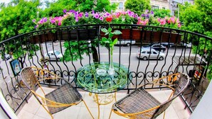 A balcony with wicker chairs and a glass table, surrounded by a metal railing. - Hotel 52 (Odesa)