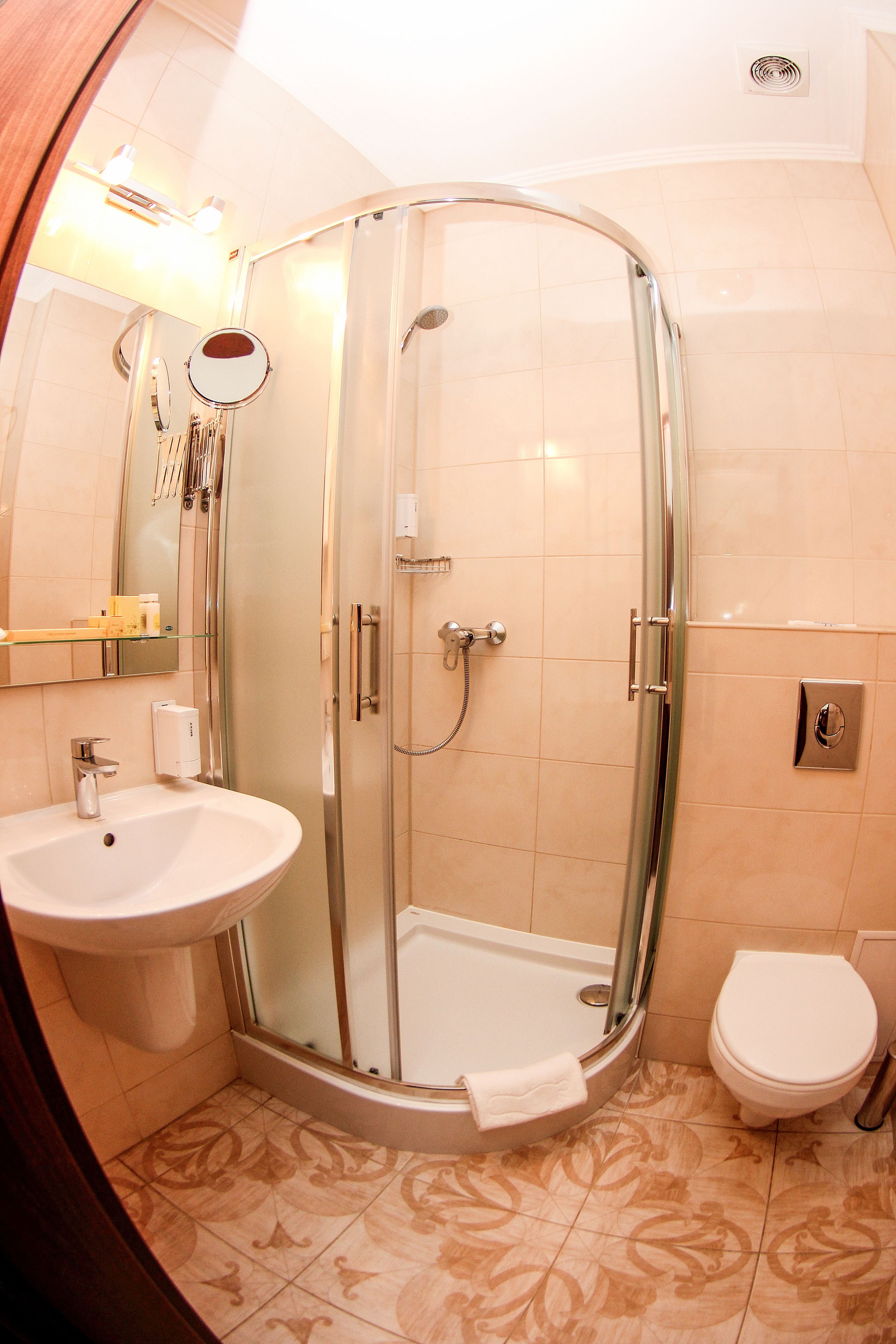 A bathroom with a glass-enclosed shower, a sink, and a toilet.