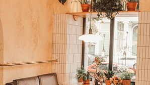 A cozy corner with a sofa, dining table, chairs, and potted plants. - Hotel 52 (Odesa)