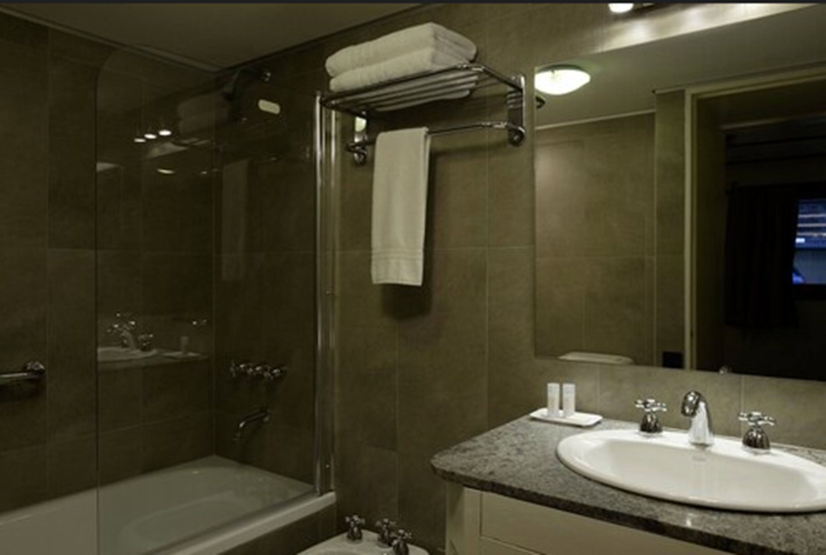 A modern bathroom with a glass-enclosed shower, a standalone bathtub, and a sink with a vanity.