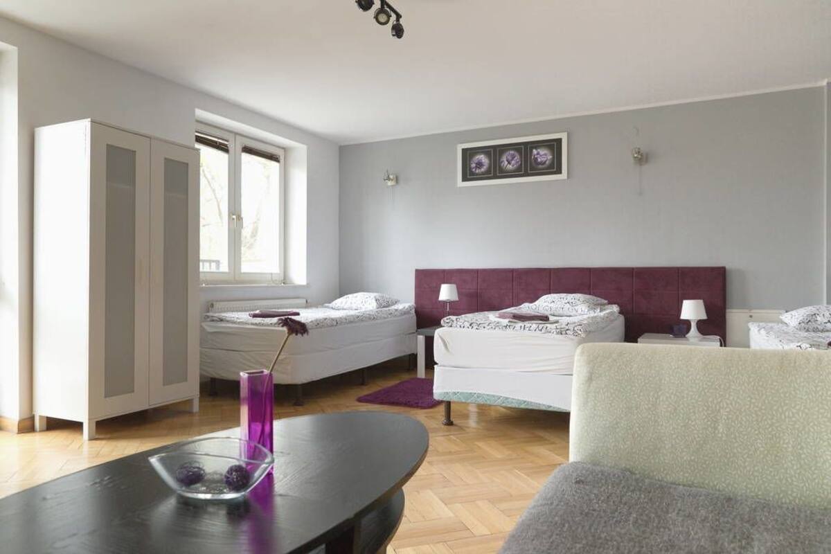 A modern bedroom with two beds, a desk, and a chair.