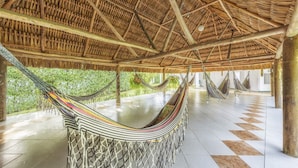 A spacious area with a thatched roof and hammocks. - Hotel Santa Barbara (Villavicencio)