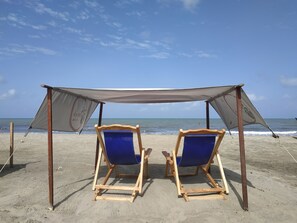 Relax in comfort under a spacious canopy, surrounded by the soothing sounds of the ocean.
