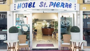 The entrance of Hotel St. Pierre with a reception desk, seating area, and a clear view of the interior. - St. Pierre (Rimini)