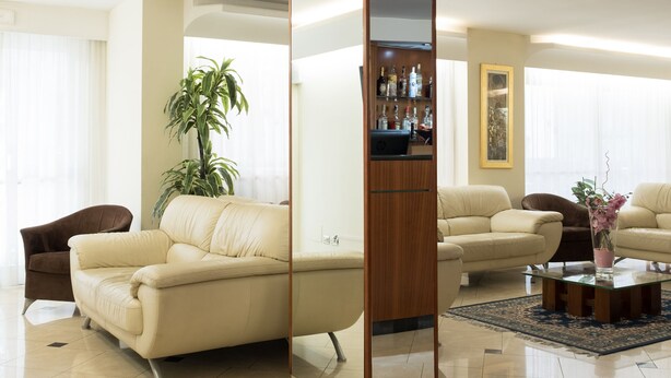 A modern living room with a beige sofa, a coffee table, and a tall wooden column. - St. Pierre (Rimini)