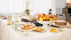 A buffet table with various food items, including pastries, fruits, and a cake. - St. Pierre (Rimini)
