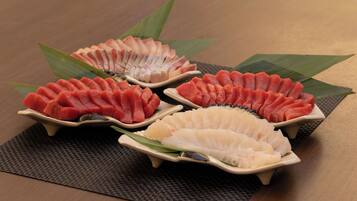 Tres porciones de sashimi sobre una mesa con posavasos.