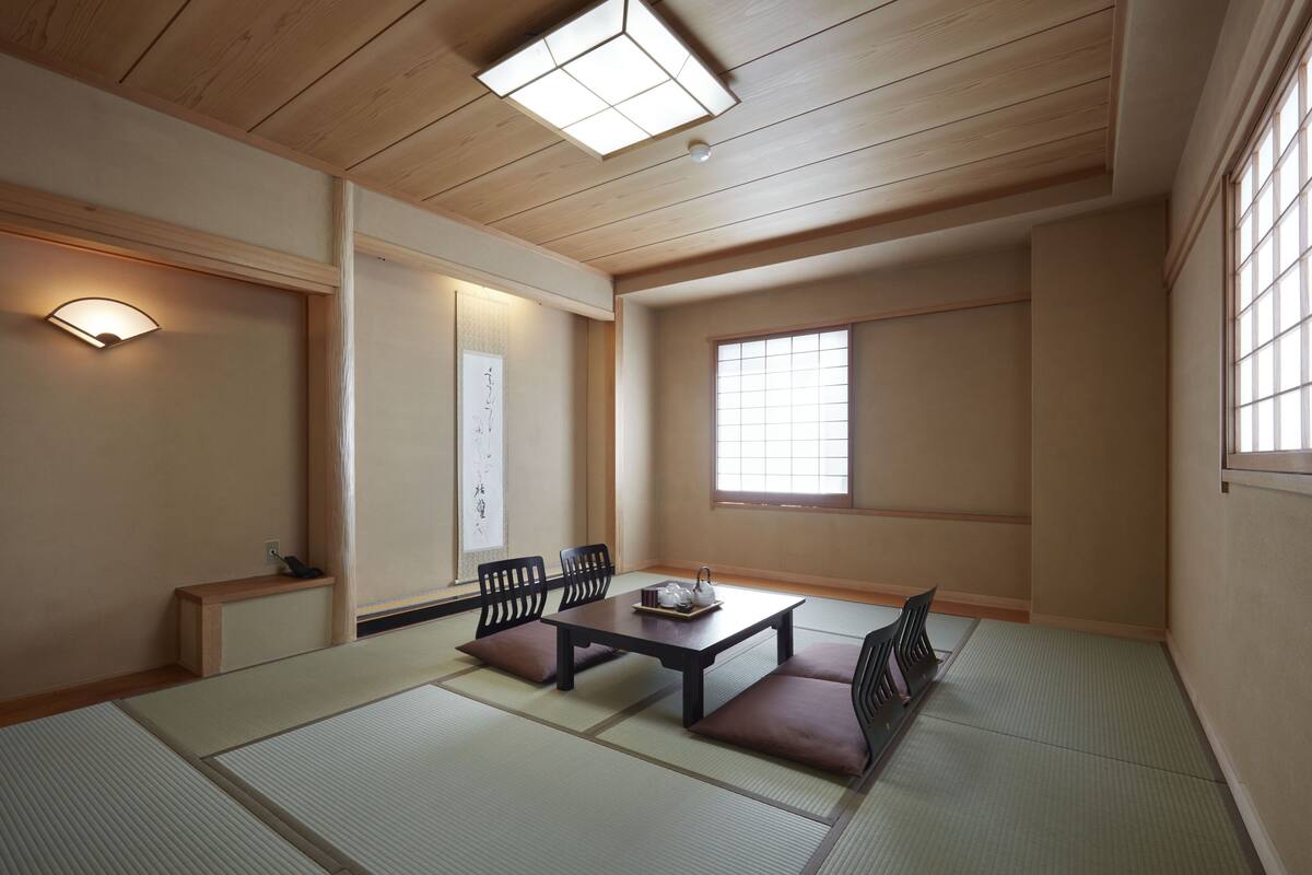 A traditional Japanese room with tatami flooring, a low table, and sliding doors.