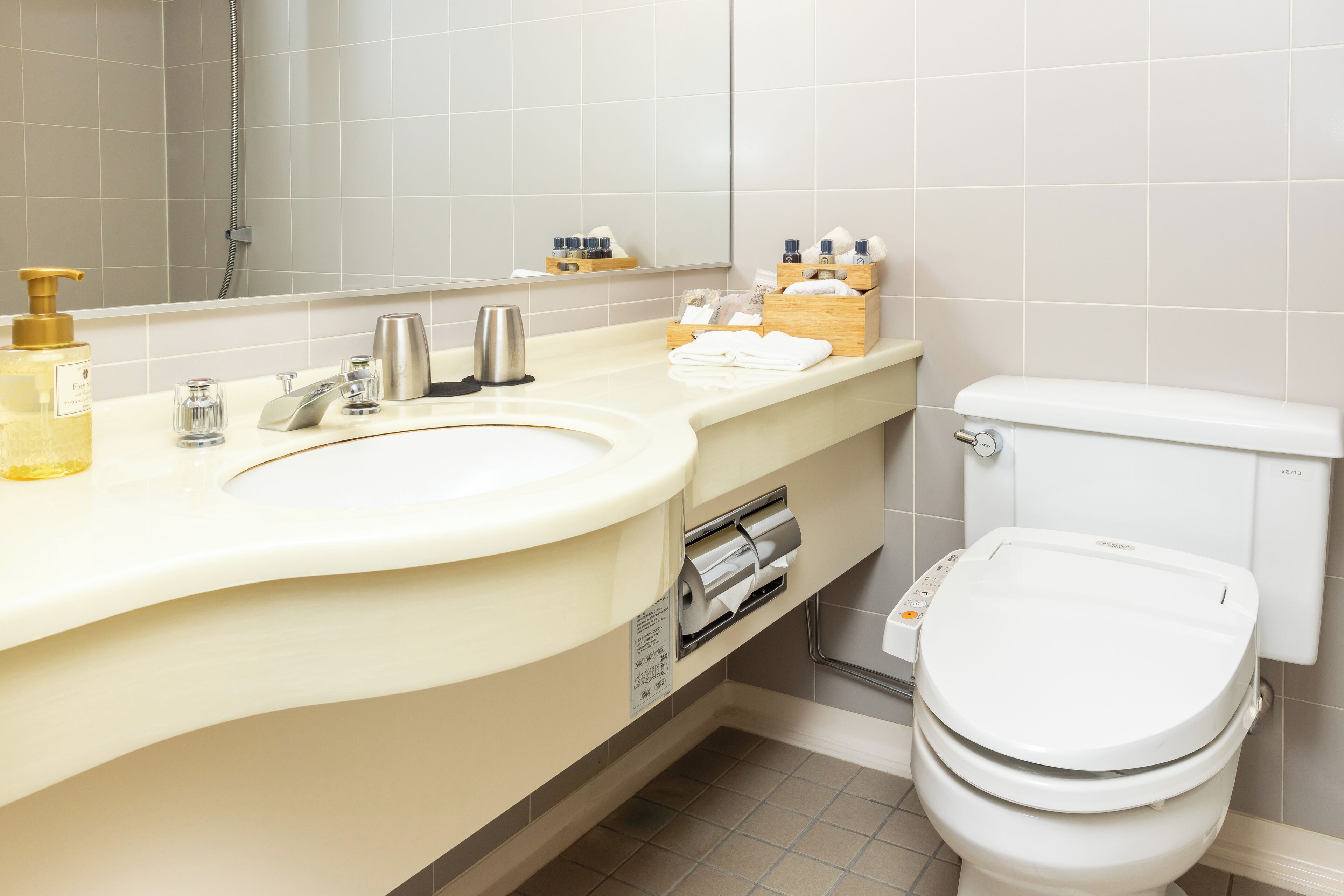 A modern bathroom with a dual sink vanity, a toilet, and a shower area.