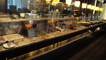Un mostrador de buffet con diferentes alimentos y una máquina de café.