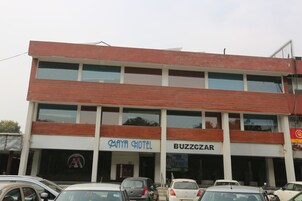 Un edificio de varios pisos con letreros que indican 'Maya Hotel' y 'Buzzcazar'.