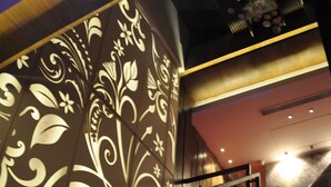 A staircase with a decorative wall featuring floral patterns. - Maya Hotel (Chandigarh)