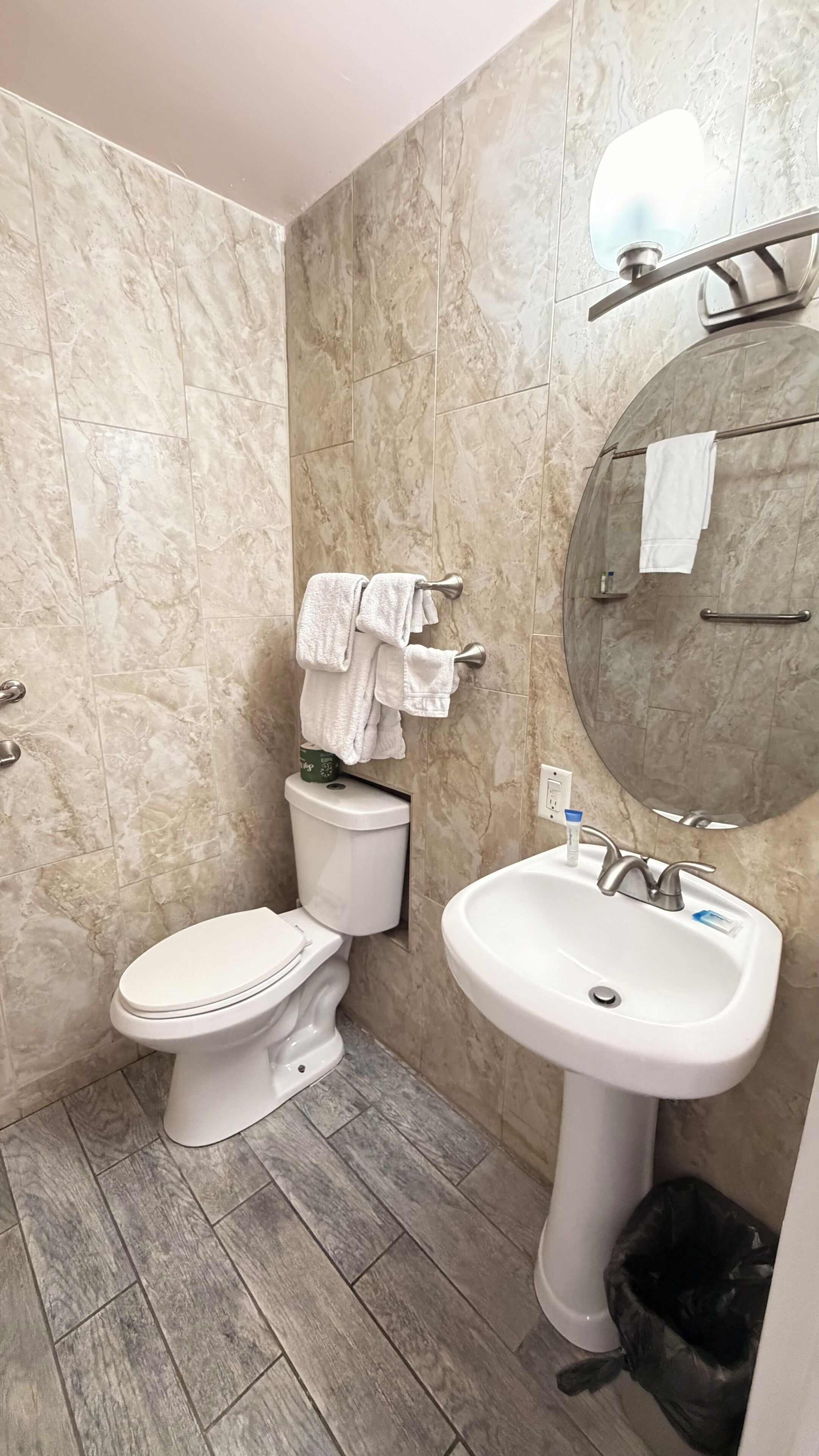 Een badkamer met toilet, wastafel en spiegel.
