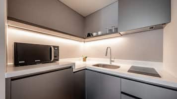 A modern kitchen with a built-in microwave, stainless steel sink, and sleek cabinetry.
