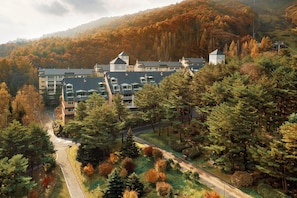 A multi-story building with a parking area and a road leading up to it, surrounded by trees. - Phoenix Resort Pyeongchang (Pyeongchang)